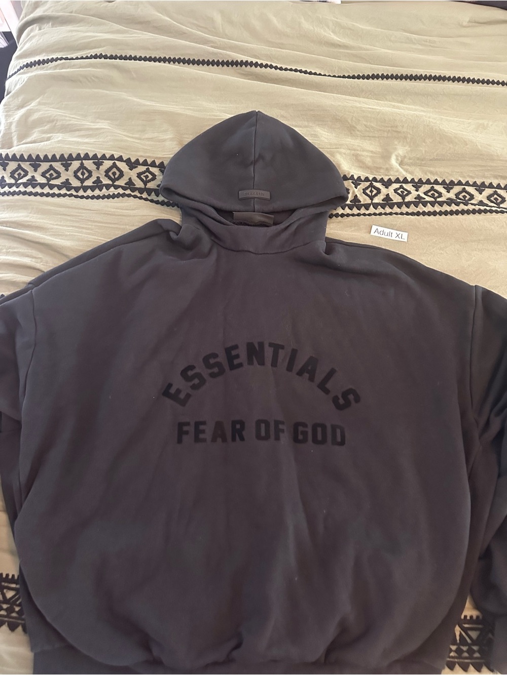 Fear of God Essentials Black Pullover Hoodie still has StockX tag attached